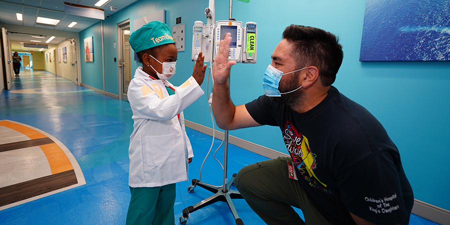 Nurse Rob high fives a patient who just ended treatment.