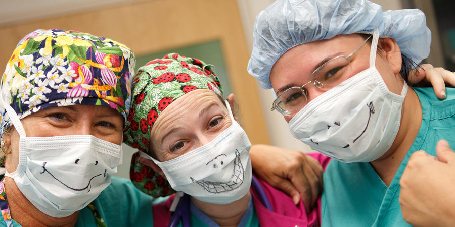 CHKD surgeons with smiley faces drawn on their surgical masks.